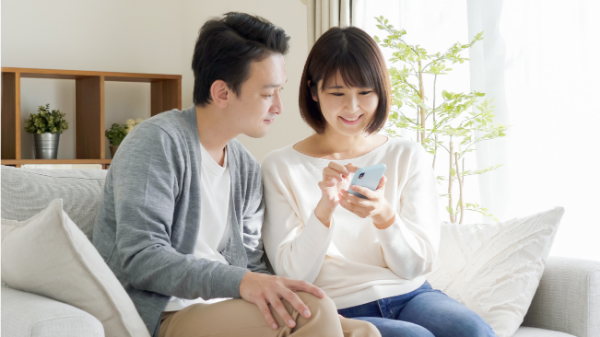 スマートフォンを見ながら話す男女